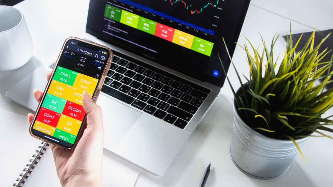 The Art of Drawing Readers In: Your attractive post title goes here Person analyzing stock market trends on smartphone and laptop.
